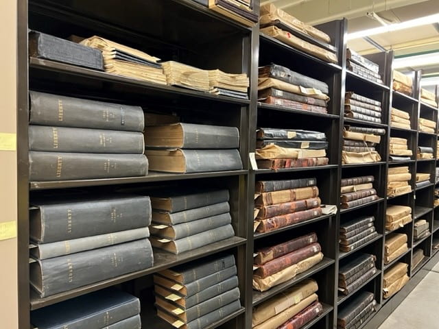 large bound volumes stacked on a shelf